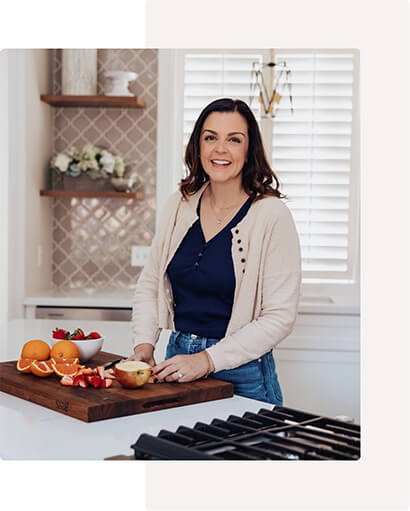 Mary Ellen in the kitchen with a chopping fruit on a block